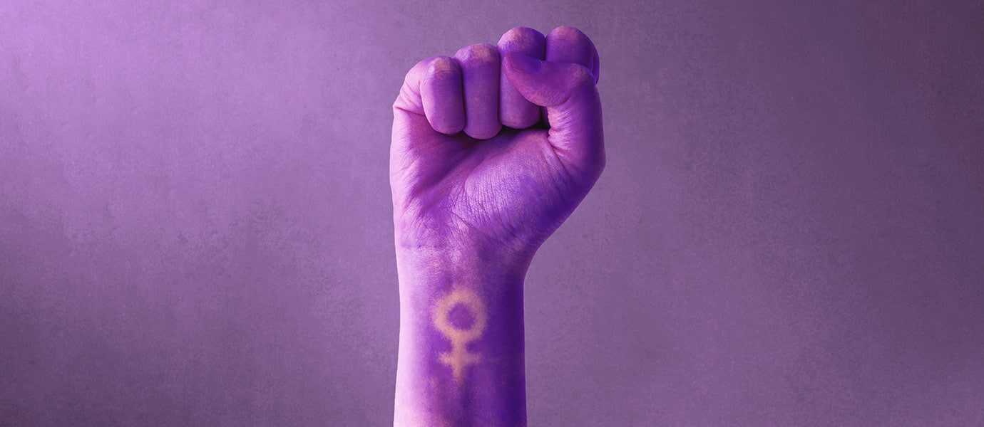 Raised purple fist of a woman for international women's day and the feminist movement. March 8 for feminism, independence, freedom, empowerment, and activism for women rights